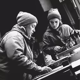 two people wearing hats are looking at something on an object