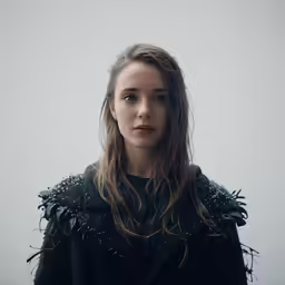 a woman with long hair in an odd jacket