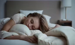a woman is laying down on the bed with her eyes closed