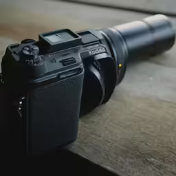 a camera with the lens resting on the ground