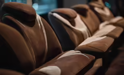 several empty seats in a row that are brown and black