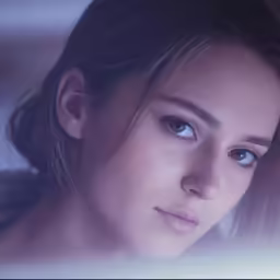 a woman looking down at the camera with her face half turned to a sad look