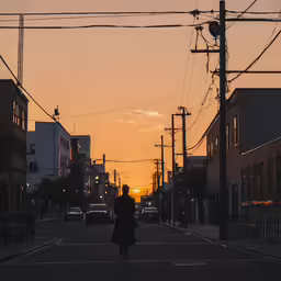 a person walking down the street with wires above