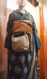 a female mannequin with an orange shirt and a bag