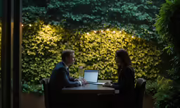 the man and woman are talking and sitting at the table