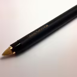 a pen with gold tips on it and the tip of a highlighter