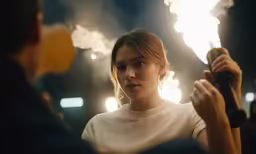 a person holding a microphone up to their face while watching fireworks