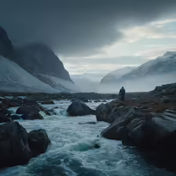 a man standing on rocks near a rushing river