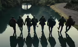 group of young people walking up and down the side of a river