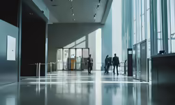a group of people walking into the lobby of an office building