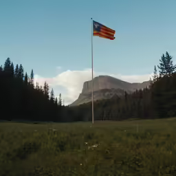 a big mountain with a flag flying from the top