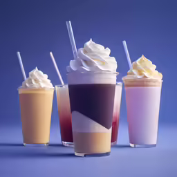 three different kinds of coffee and milk in shot glasses