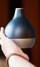 the hand is holding up an odd looking lamp