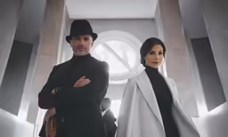 two people in suits and hats standing together