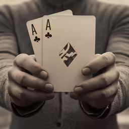 a man holding three playing cards in his hands