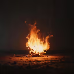 a black night with a bright fire blazing into the dark