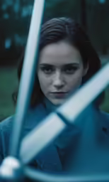 a young girl posing for a picture, behind the screen is a knife