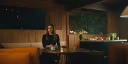 a girl sitting at a table in a restaurant