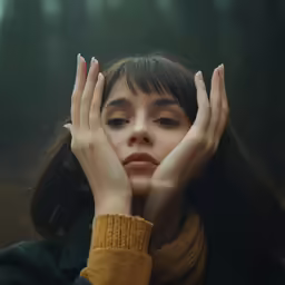 a girl covering her face with her hands