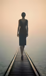 woman walking on a jetty towards the ocean