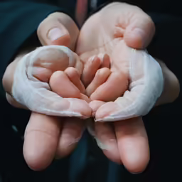 a person with multiple hands covered in bandages