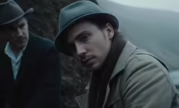 two men, one in a gray jacket and one in a black hat