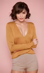 a women wearing beige is posing for the camera
