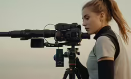 a young girl in a gray shirt is on the side of the camera
