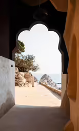 an archway is leading to the beach under it