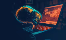 a man with blonde hair on his head using a laptop