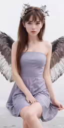 a woman dressed in a gray dress and holding an angel wing