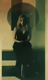a woman in black sitting on a wall