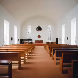 an empty church with benches, tables and speakers