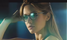 woman in glasses on dark background, looking at camera