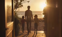 a father is holding his two daughters hand as the sun sets