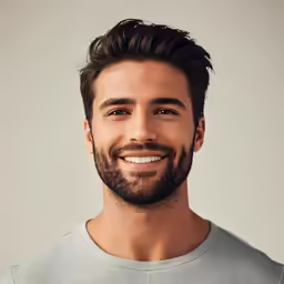 a man with long hair smiling at the camera