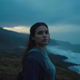 a woman is standing in a scenic outdoor setting