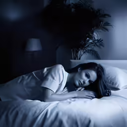 the woman is lying in bed smiling for the camera