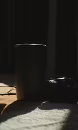 the camera is laying on the floor and next to the coffee cup