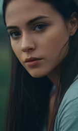 a woman wearing blue is standing in the grass