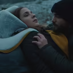 a man and woman with the hood up, embracing