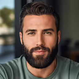 a young man is looking directly ahead with a goatee