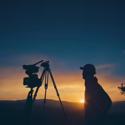 a person is watching the sun set behind a camera