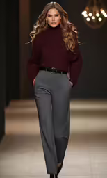 a model wearing a sweater and trousers at the catwalk
