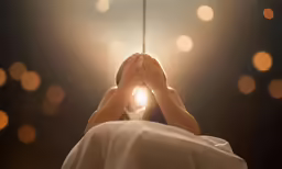 a person that is laying down with their hands on a string