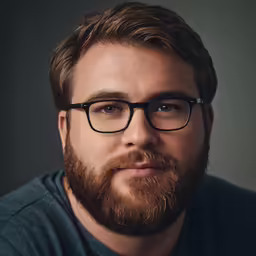 the young man is wearing glasses looking at the camera