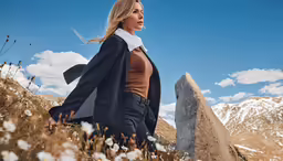 a woman is posing on the ground in a field