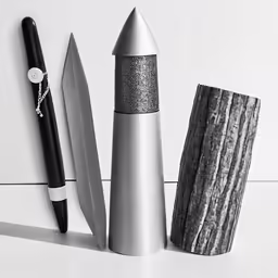 three pens and an object on a white surface