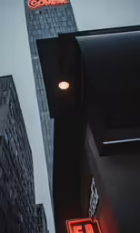 the logo of a bike shop and building is lit