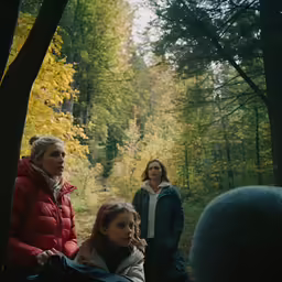 several people in the woods standing next to trees